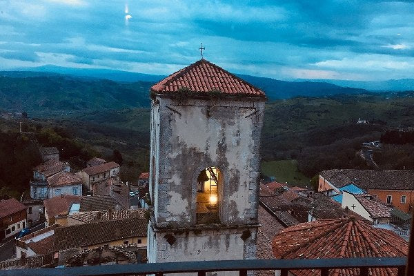 Un campanile al tramonto sopra i tetti del paese